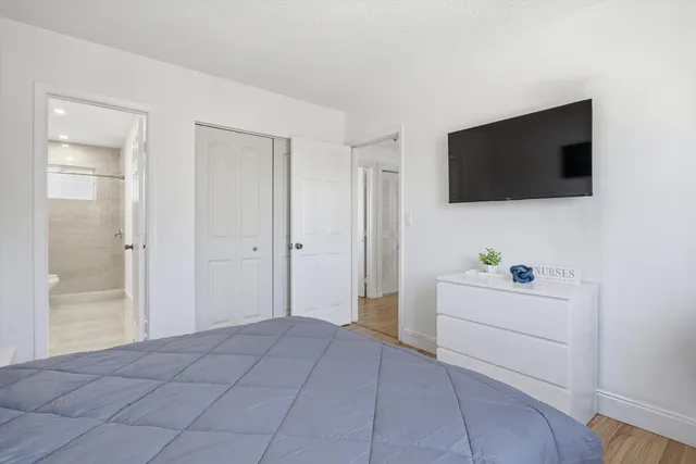 a bedroom with a bed and a flat screen tv