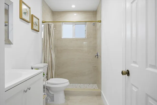 a bathroom with a sink a toilet and shower