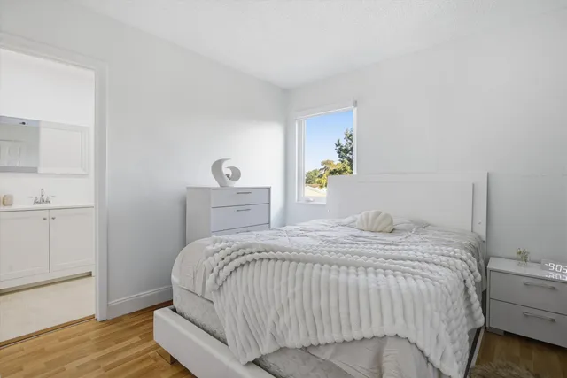 a bedroom with a bed and wooden floor