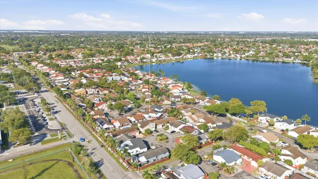 an aerial view of ocean and residential houses with outdoor space