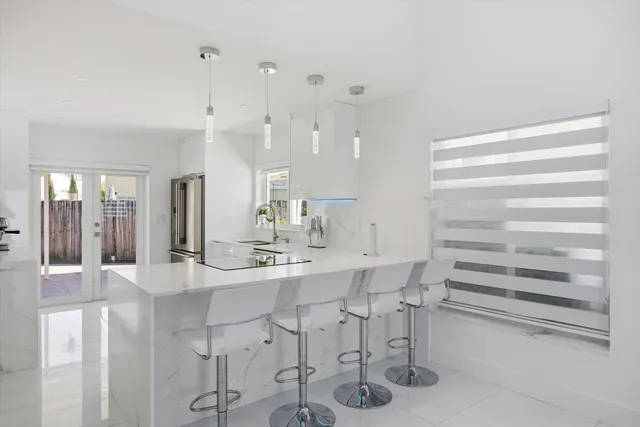 a kitchen with stainless steel appliances kitchen island granite countertop a table and chairs in it