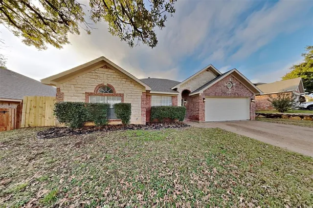 a view of a house with a yard and large tree