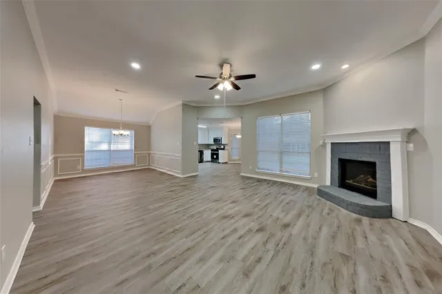 an empty room with windows and fireplace