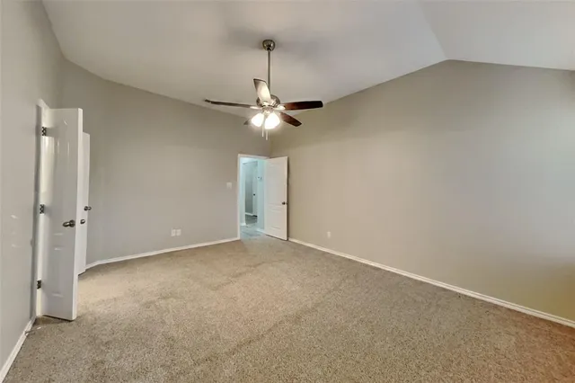 an empty room with a ceiling fan and a window