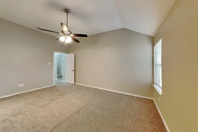 an empty room with a ceiling fan and a window