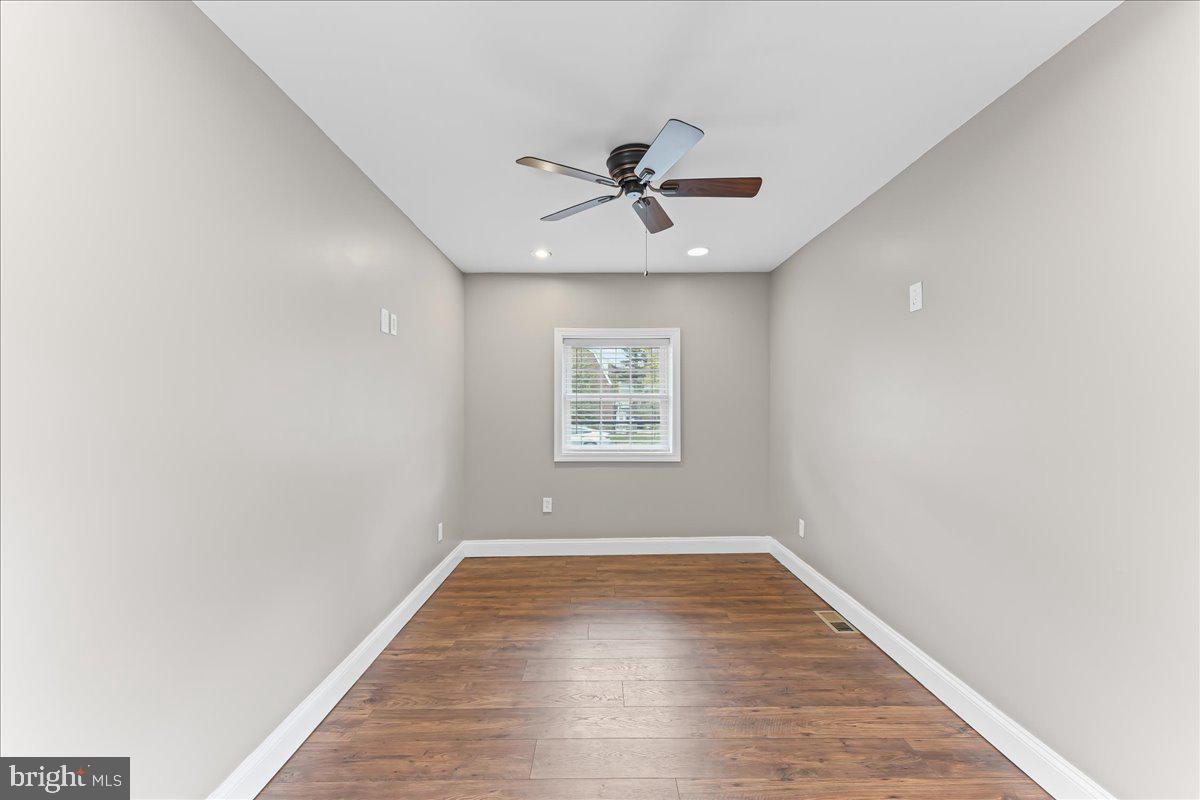 200 Fairview Road Springfield, PA 19064 - Photo 13 of 43 an empty room with wooden floor ceiling fan and windows