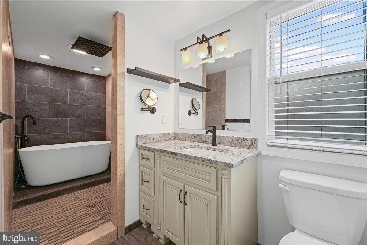 200 Fairview Road Springfield, PA 19064 - Photo 17 of 43 a bathroom with a granite countertop sink a toilet a mirror and bathtub