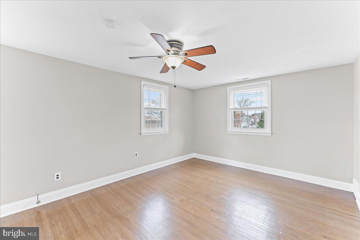 200 Fairview Road Springfield, PA 19064 - Photo 23 of 43 an empty room with wooden floor ceiling fan and windows