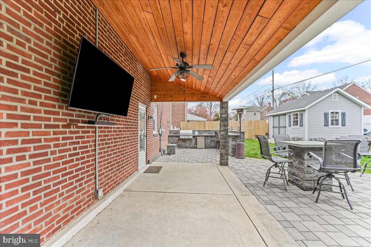 200 Fairview Road Springfield, PA 19064 - Photo 34 of 43 a view of a patio with a table and chairs under an umbrella with a tv