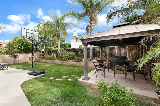 a view of a patio with table and chairs potted plants and palm trees