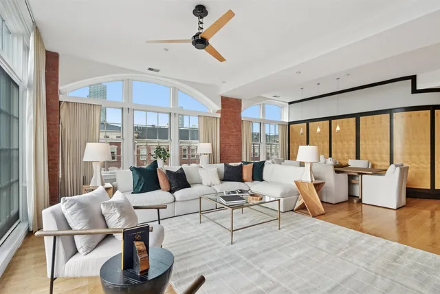 a living room with fireplace furniture and a large window