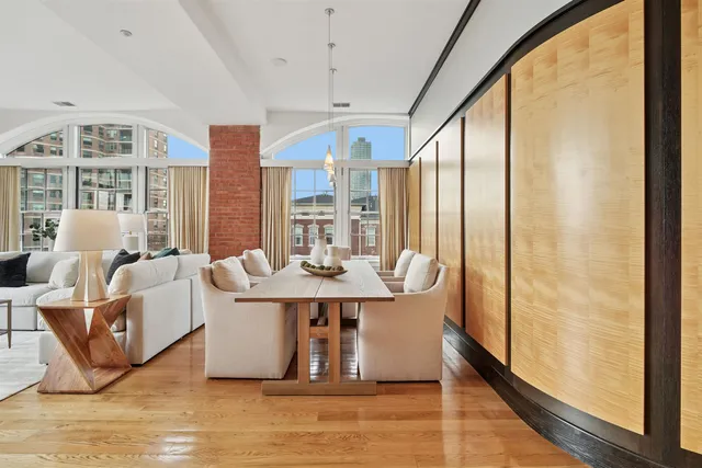 a dining room with large window a chandelier and wooden floor