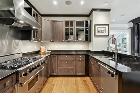 a kitchen with stainless steel appliances granite countertop a stove and a sink