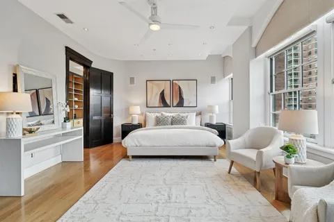 a spacious bedroom with a bed a couch and a potted plant