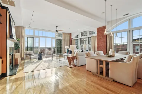 a living room with furniture a large window and chandelier