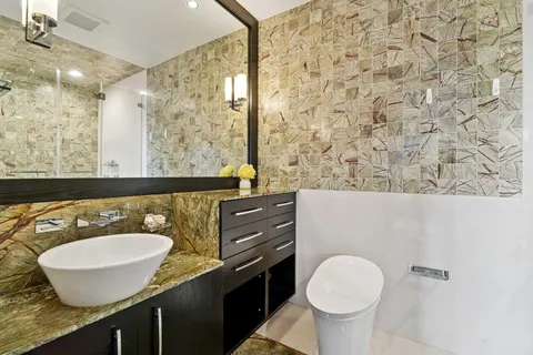 a bathroom with a granite countertop sink and a mirror