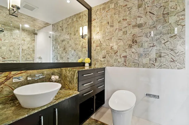 a bathroom with a granite countertop sink and a mirror