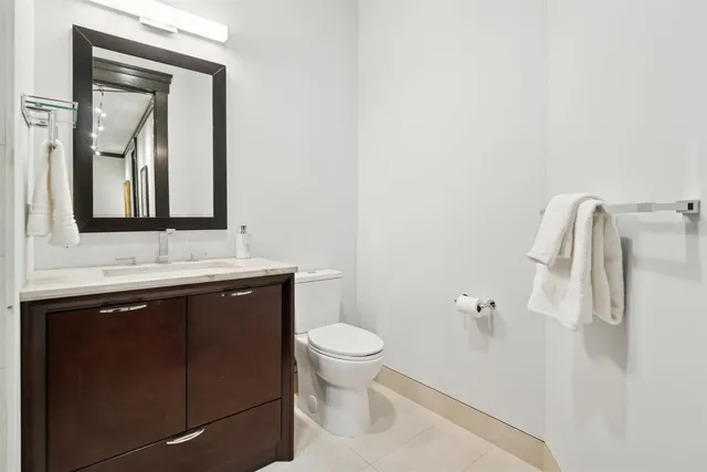 a bathroom with a sink a toilet and a mirror