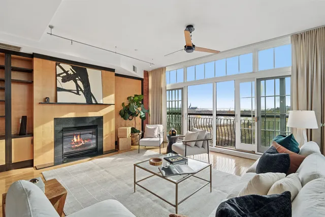 a living room with furniture a large window and a fireplace