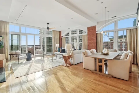 a living room with couches a coffee table and chairs with wooden floor