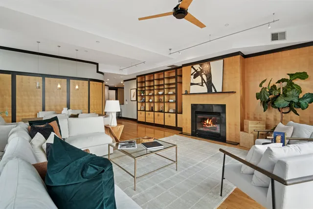 a living room with fireplace furniture and a large window