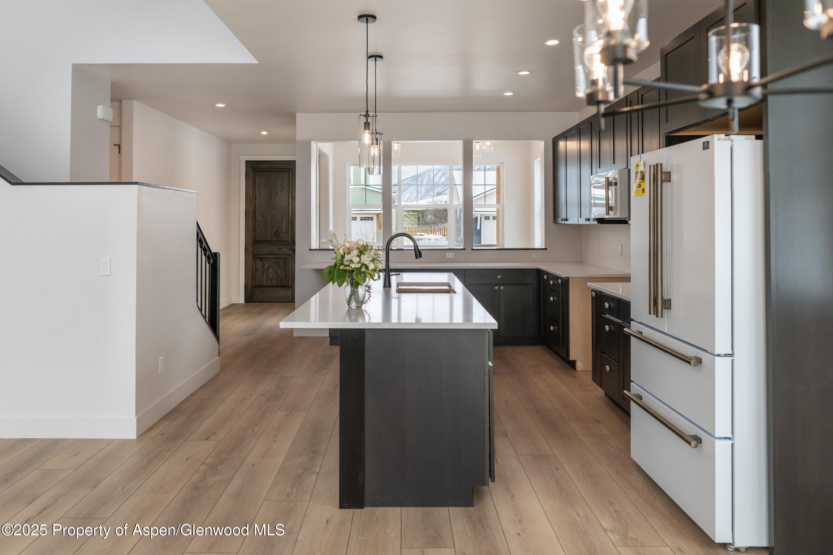 42 Mount Yale Court New Castle, CO 81647 - Photo 6 of 26 a kitchen with stainless steel appliances granite countertop a refrigerator a sink dishwasher a stove and a dining table with wooden floor