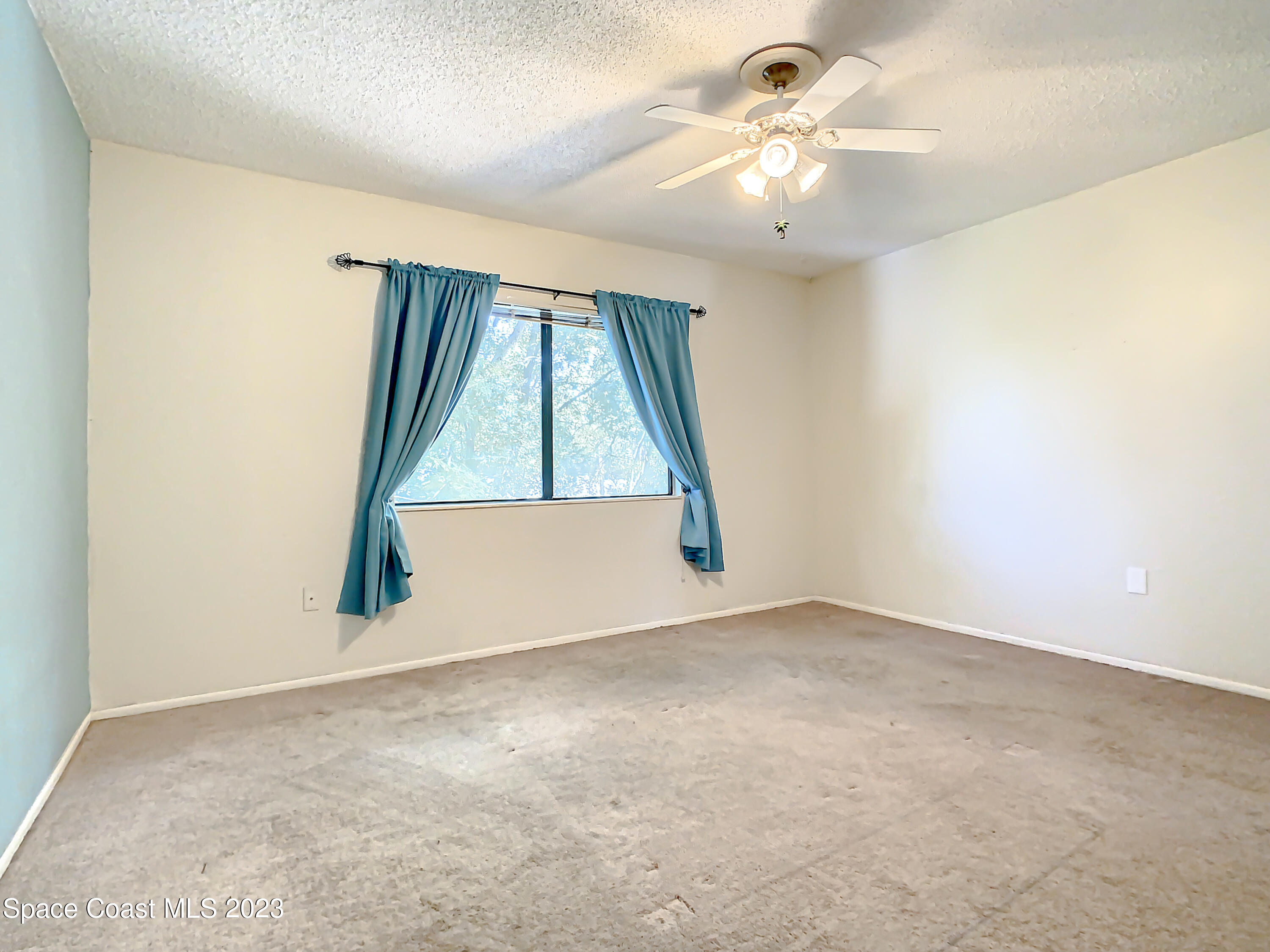 4859 Sisson Road Titusville, FL 32780 - Photo 20 of 30 an empty room with a window and a ceiling fan