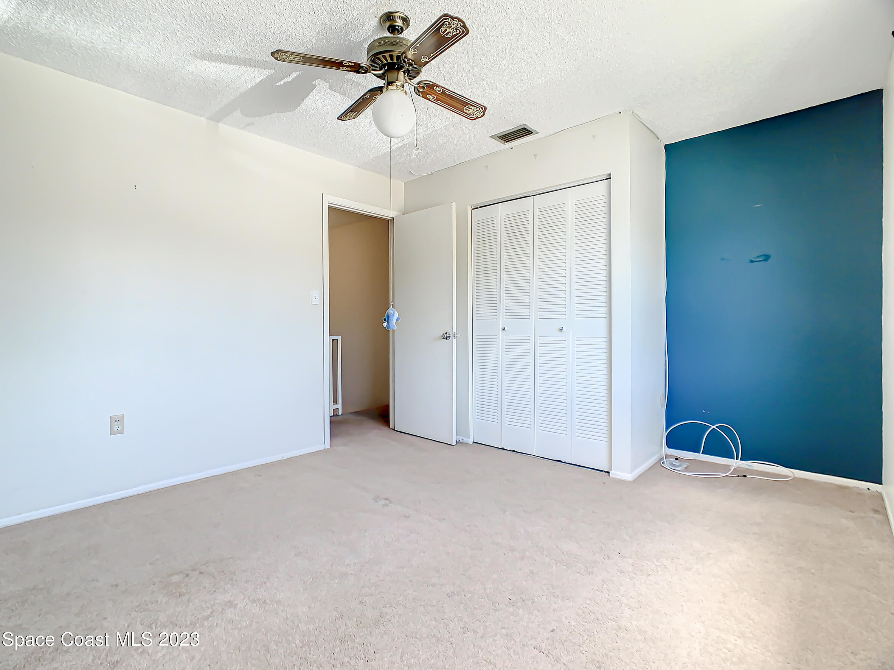 4859 Sisson Road Titusville, FL 32780 - Photo 23 of 30 an empty room with closet and a ceiling fan