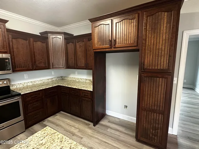 a kitchen with granite countertop wooden cabinets and granite counter tops