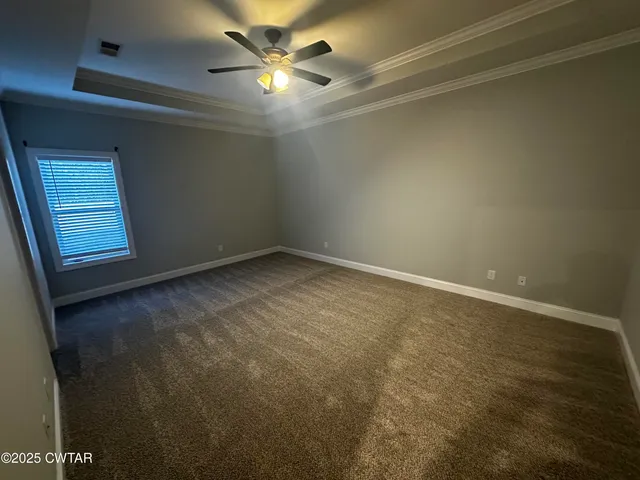 en empty room with windows and fan