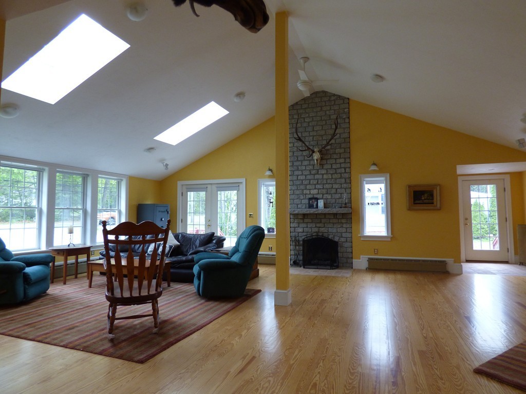345 Ayer Road Harvard, MA 01451 - Photo 3 of 30 a living room with furniture a fireplace and wooden floor