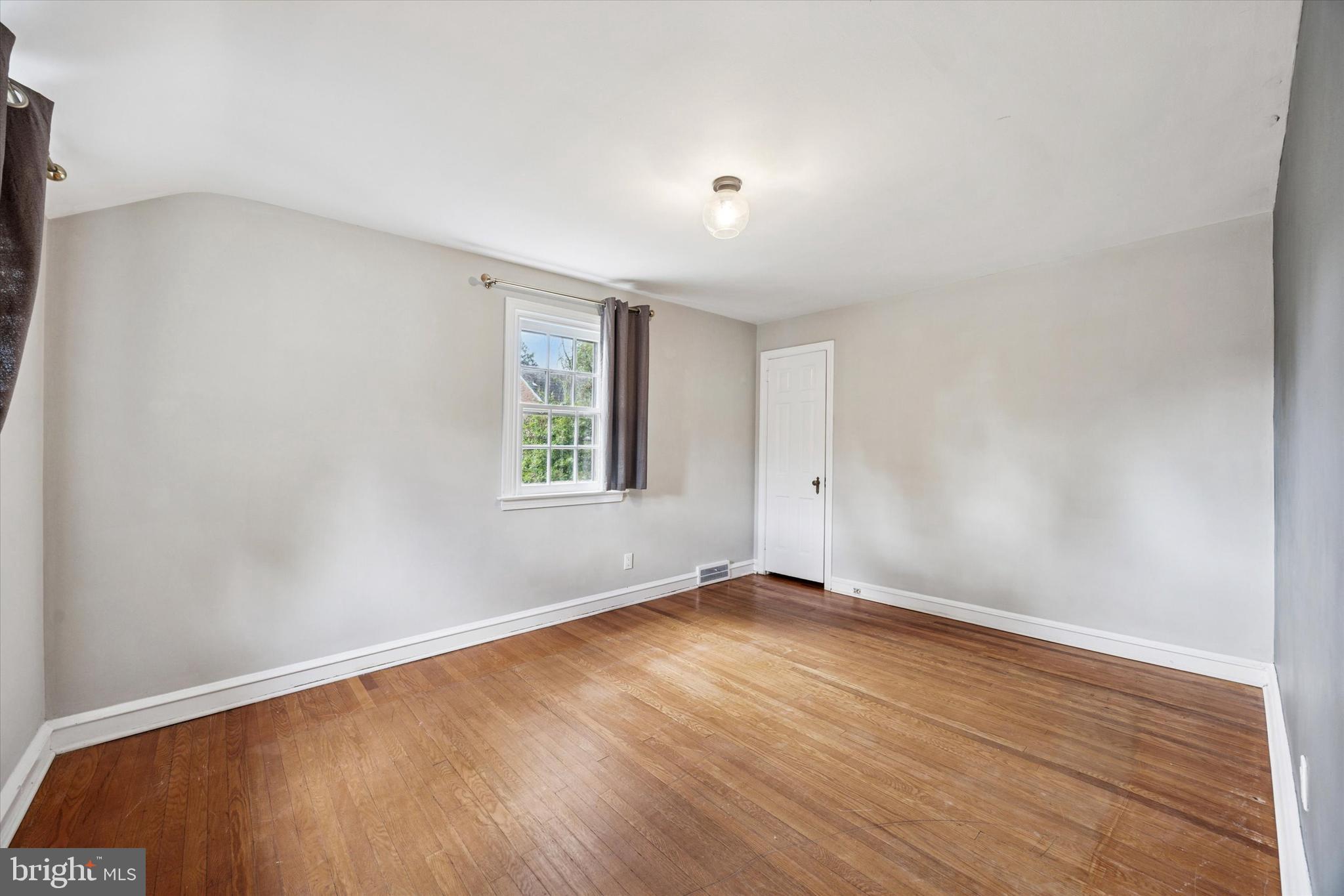 1612 Earlington Road Havertown, PA 19083 - Photo 23 of 35 an empty room with wooden floor and windows
