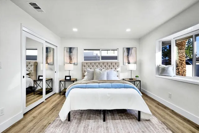 a bed room with a bed mirror and a window