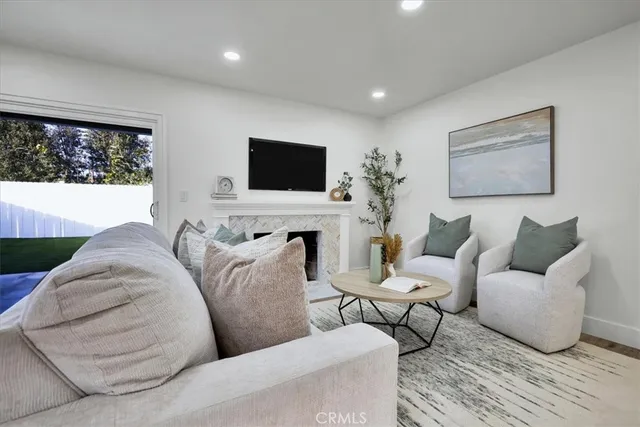 a living room with furniture a flat screen tv and a floor to ceiling window