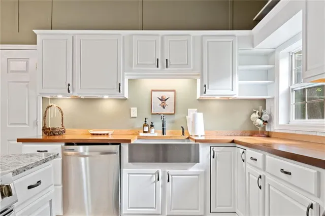 a kitchen with stainless steel appliances granite countertop a sink stove and cabinets