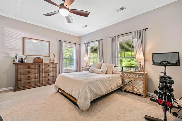 a bedroom with a bed a dresser and a chandelier