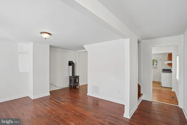 a view of empty room with wooden floor