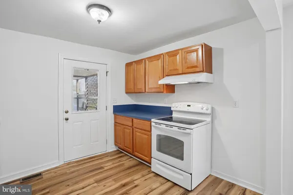a kitchen with a stove top oven and cabinets