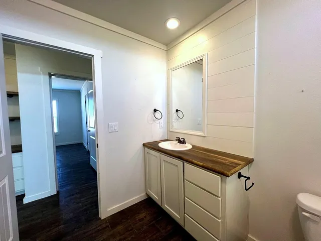 a bathroom with a granite countertop sink toilet and shower