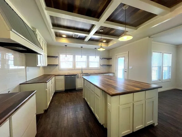 a kitchen with counter top space a sink and wooden floor