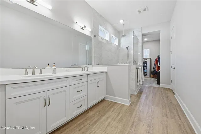 a spacious bathroom with a double vanity sink and a mirror