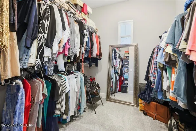 a view of walk in closet with clothes