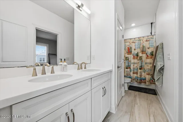 a bathroom with a double vanity sink mirror and shower