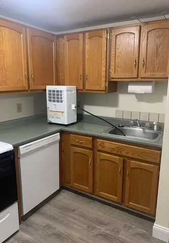 a kitchen with granite countertop cabinets stainless steel appliances a sink and wooden floor