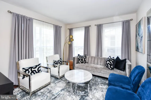 a living room with furniture and floor to ceiling windows