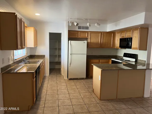 a kitchen with a refrigerator a stove top oven a sink and a refrigerator