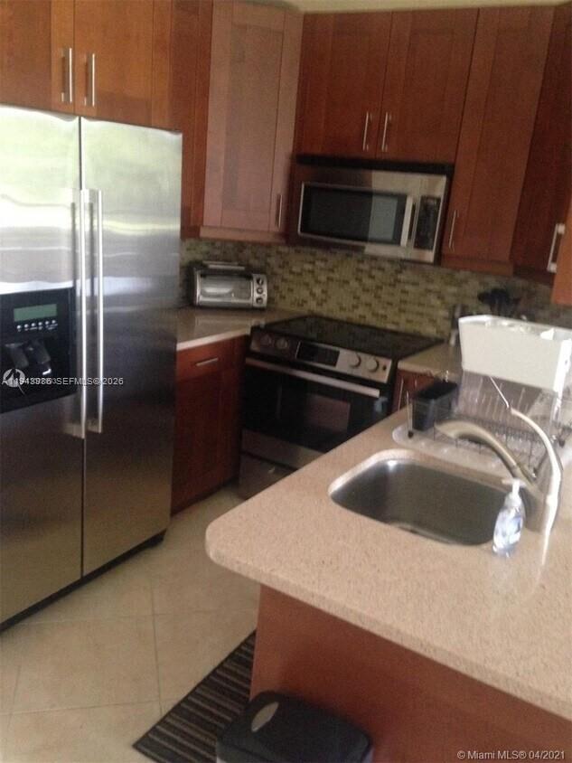 901 Lyons Road, Unit 1208 Coconut Creek, FL 33063 - Photo 5 of 5 a kitchen with a sink and a refrigerator
