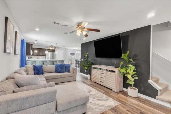 a living room with furniture a flat screen tv and a potted plant