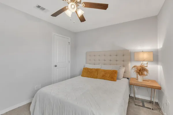 a bedroom with a bed and a chandelier fan