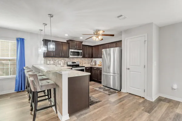 a kitchen with kitchen island granite countertop a sink a counter and cabinets